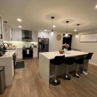 A modern kitchen with an island counter, pendant lighting, and sleek stainless steel appliances.