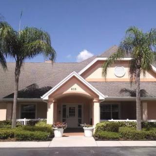 A suburban building surrounded by palm trees on a sunny day.