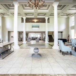 A luxurious and spacious lobby featuring large columns, elegant chandeliers, and comfortable seating.