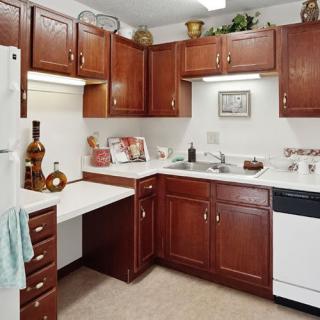 A cozy kitchen with wooden cabinets and various appliances.