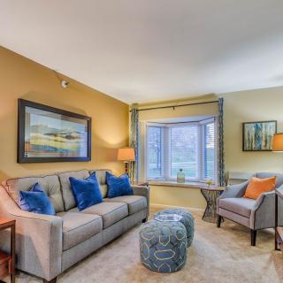 A cozy living room with a sofa, armchair, and stylish decor.