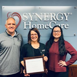Team members celebrating an achievement at Synergy HomeCare.