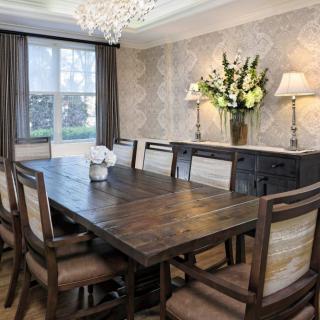 A beautifully decorated dining room with a wooden table, chairs, and a chandelier.