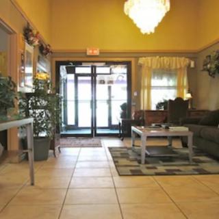 A cozy lobby area with a seating arrangement, chandelier, and potted plants.