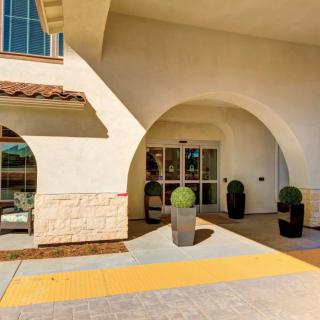 A building entrance featuring an archway and decorative potted plants.