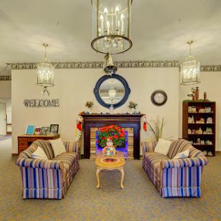 A cozy living room featuring striped sofas, decorative accents, and a warm fireplace.
