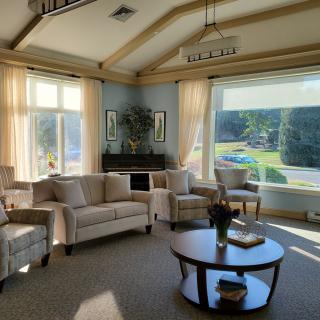 A cozy living room with plush seating and abundant natural light streaming in through large windows.
