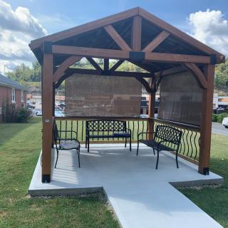 A wooden gazebo with benches providing a shaded outdoor seating area.