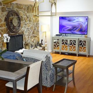 A stylish living room with a stone fireplace and modern furniture.