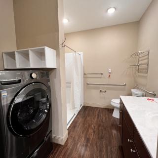 A modern bathroom with integrated laundry facilities.