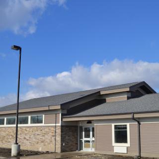 A modern building under a blue sky with scattered clouds.