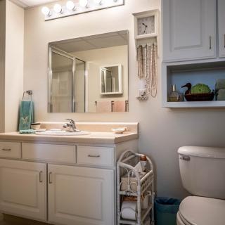 A tidy bathroom with a vanity, mirror, and cabinet.