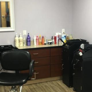 A cozy hair salon setup with a styling chair and various beauty products on a countertop.