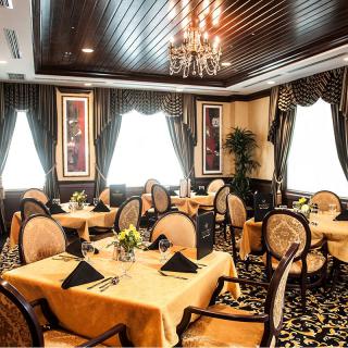 An elegant dining room with sophisticated table settings and a chandelier.
