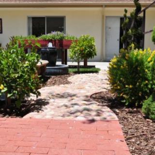 A serene garden pathway leading to a cozy patio area.