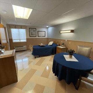 A well-lit and organized room featuring a seating area and a table, suitable for relaxation or consultations.