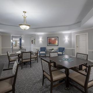 A well-lit meeting room with tables and chairs, decorated with artwork on the walls.