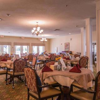 A spacious dining room with neatly arranged tables and chairs, featuring elegant decor.