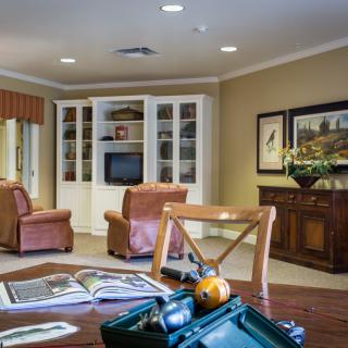 A cozy living room with comfortable armchairs, a bookshelf, and tasteful decor.