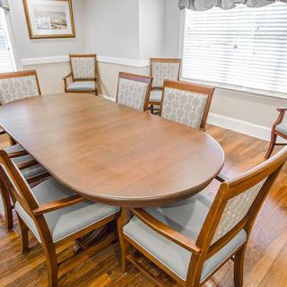 A dining room with a wooden table surrounded by chairs.