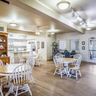 A cozy dining area featuring white wooden furniture and ample lighting.
