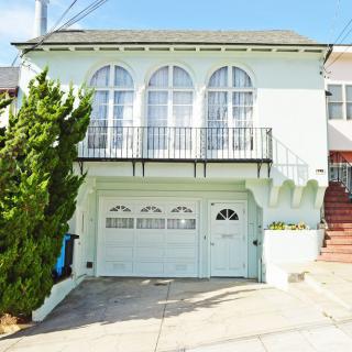 A two-story residential house with a garage and arched windows.