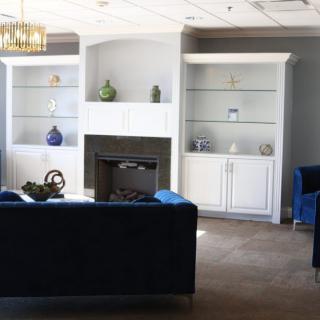 A stylish living room featuring a fireplace, built-in shelves, and elegant furniture.