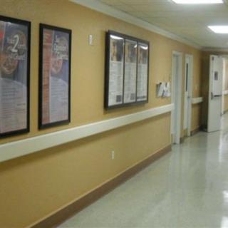 A hospital hallway with framed posters on the wall.