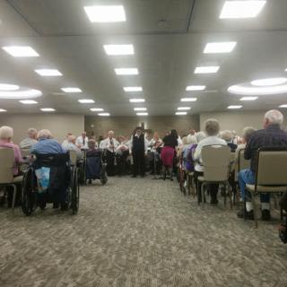 A gathering of senior citizens attending an event in a spacious hall.