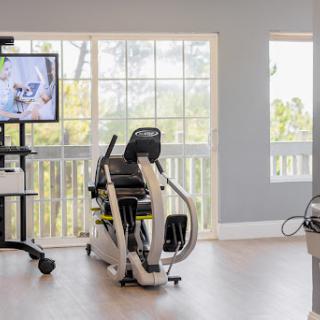 A modern exercise bike positioned near large windows, creating a bright and inviting workout area.