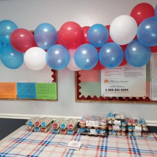 A festive table setting with colorful balloons overhead, ready for a celebration.