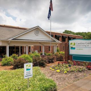 Entrance of a healthcare facility with an American flag and surrounding landscaping.