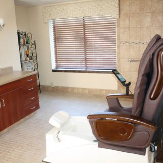 A spa room featuring a comfortable massage chair and pedicure station, designed for relaxation and wellness.