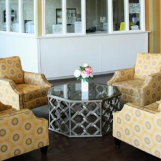 A cozy lounge area featuring patterned armchairs and a stylish glass coffee table.