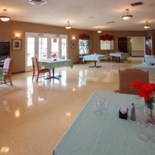 A brightly lit dining area with neatly arranged tables and chairs.