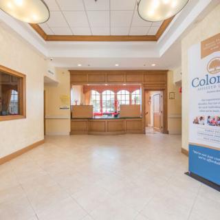 A spacious hotel lobby with a reception desk and minimalist decor.