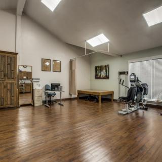 A spacious and well-lit gym room with exercise equipment.