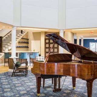 A luxurious living room featuring a grand piano, showcasing modern interior design and elegant furnishings.