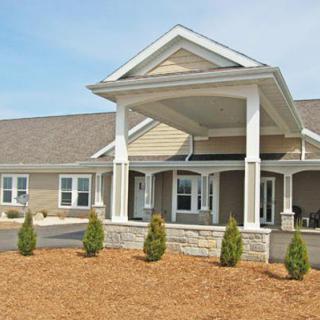 A residential building with a covered entrance and freshly landscaped front yard.