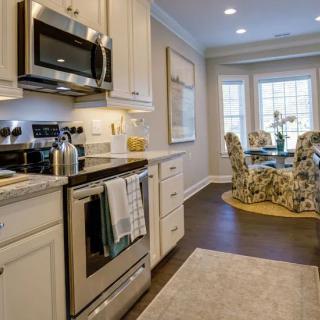 A modern kitchen with stainless steel appliances and a cozy dining area.
