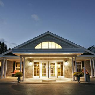 A well-lit building entrance at dusk with symmetrical architectural design.