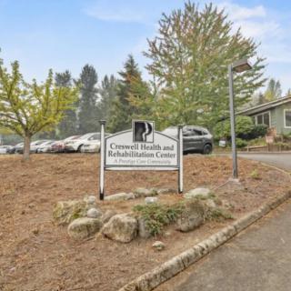 An exterior view of a building with a sign reading 'General Practice and Administration Center', surrounded by trees and parked cars.