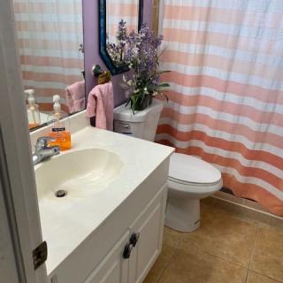 A clean and tidy bathroom with a sink, toilet, and striped shower curtain.