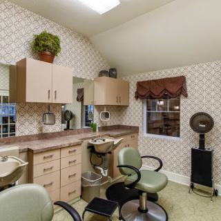 A cozy hair salon interior featuring stylish furniture and a warm atmosphere.