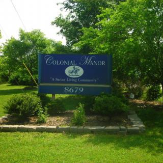 A building sign surrounded by lush greenery in an outdoor setting.