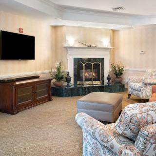 A cozy living room with a fireplace, sofa, and mounted television.