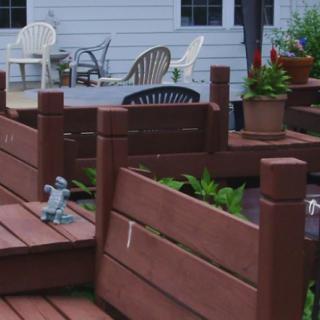 A wooden deck with outdoor furniture and decorative garden elements.