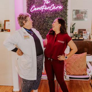 Two healthcare professionals interacting in a clinic setting.