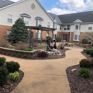A well-maintained garden and pathway leading to a large residential building.