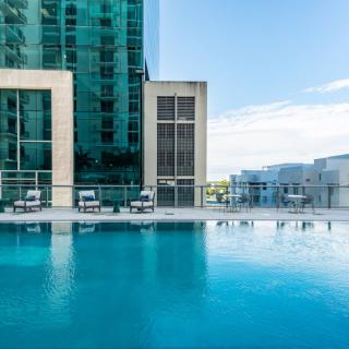 A modern high-rise building with a serene outdoor swimming pool.